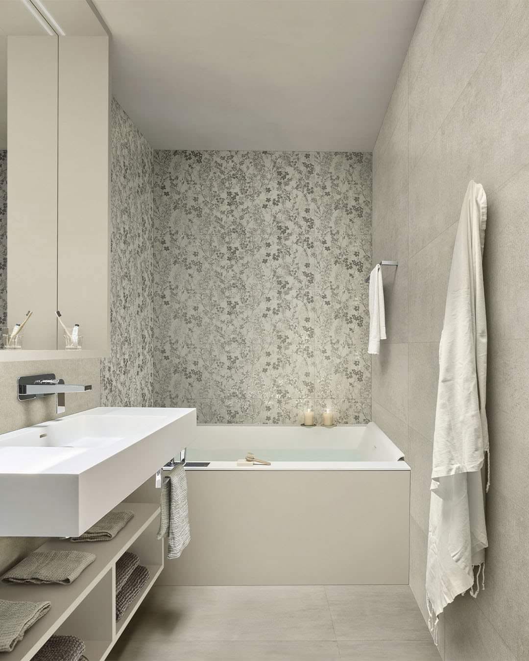 Bagno realizzato con vasca, grandi lastre e parete a mosaico